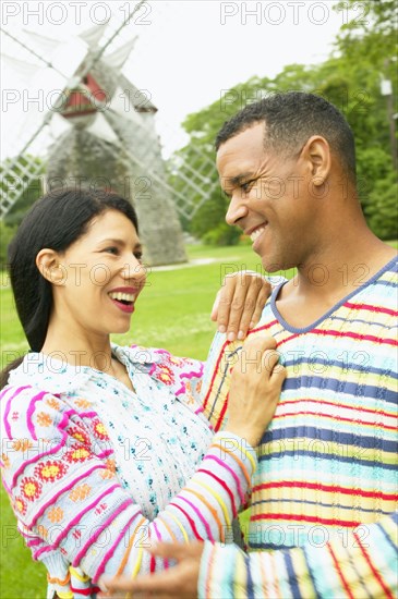 Couple hugging by windmill