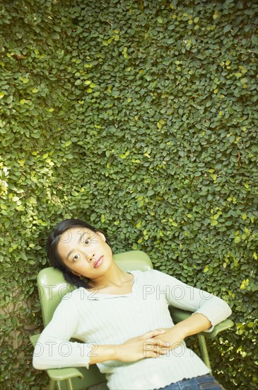 Portrait of woman sitting in chair outdoors