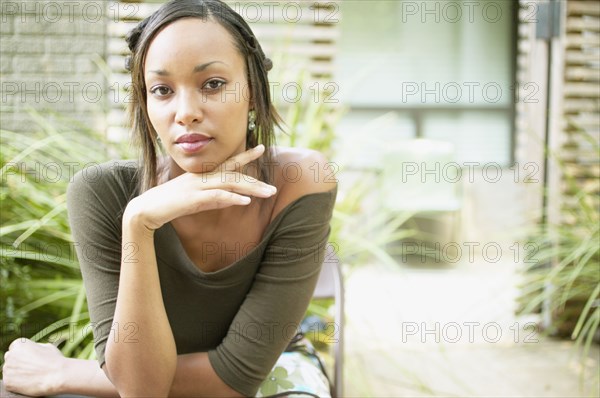 Portrait of woman resting head on hand outdoors