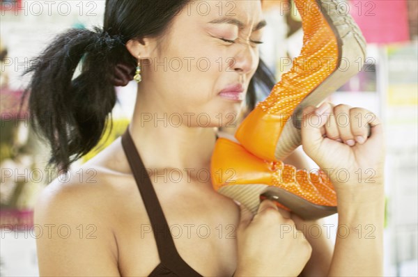 Teenage girl smelling shoe