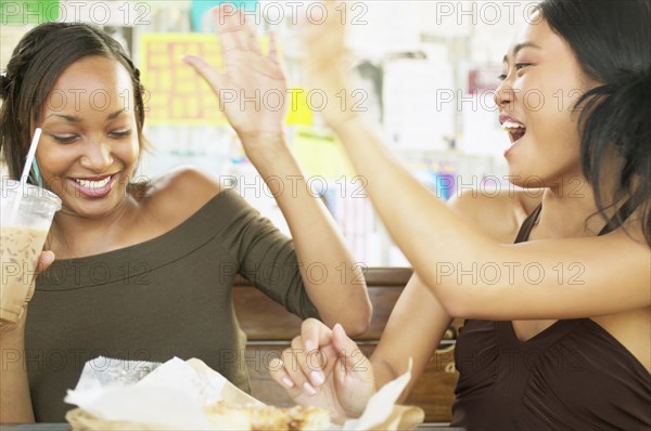 Two female friends giving each other high five