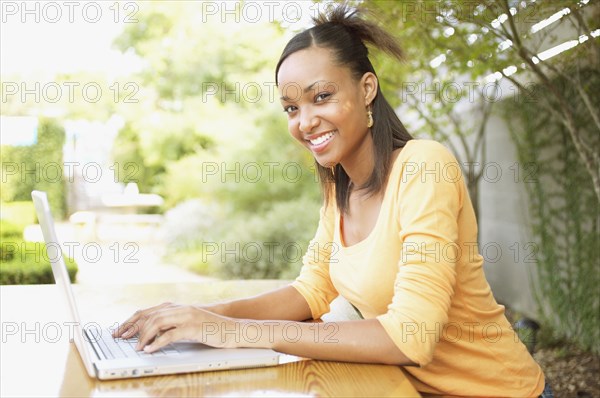 Portrait of teenage girl typing on laptop