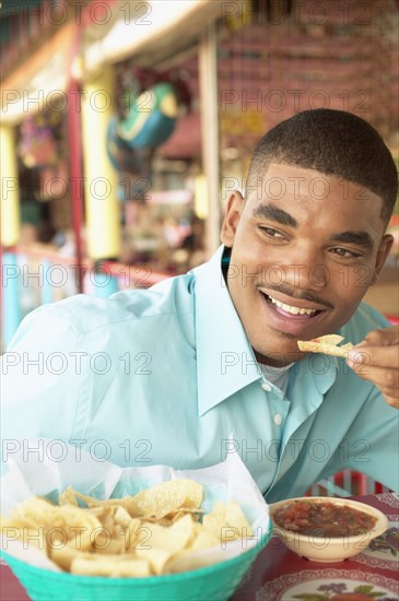 Man eating chips and salsa