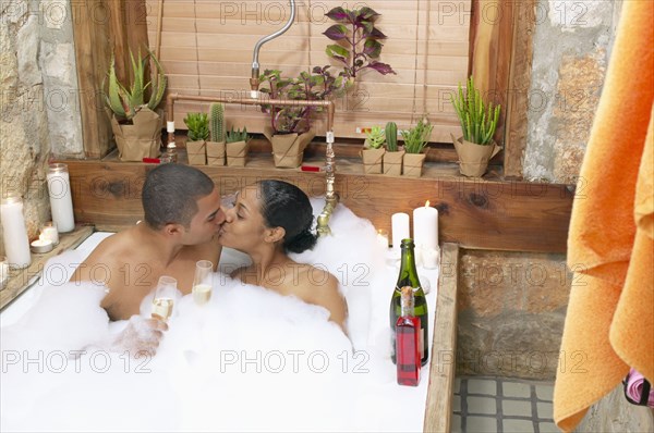 Couple in bubble bath kissing