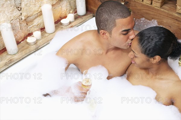 Couple kissing in bubble bath