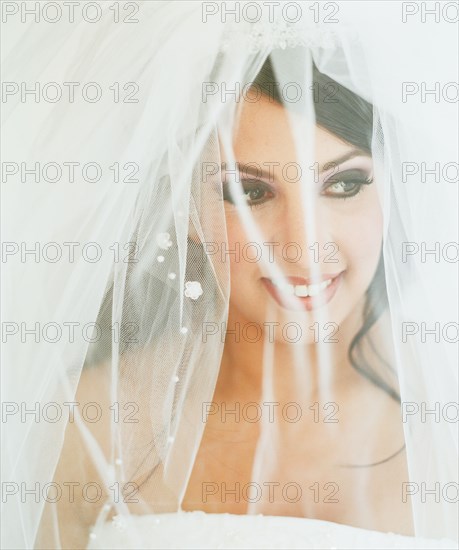 Young bride posing with veiled face