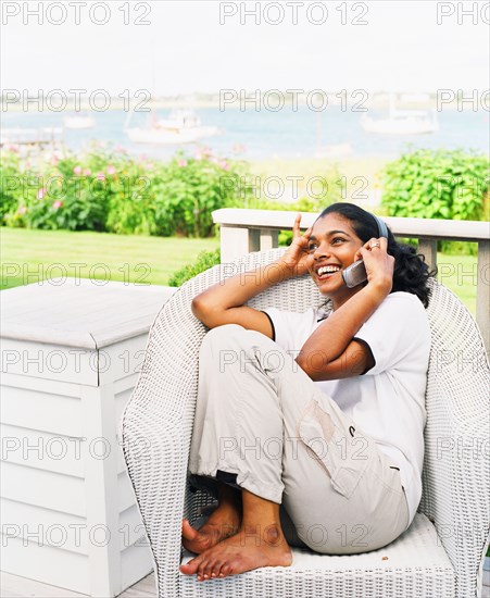 Young woman using cell phone on porch