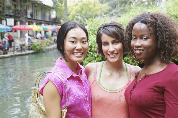 Three female friends standing outside