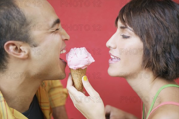 Profile view of couple sharing ice cream cone