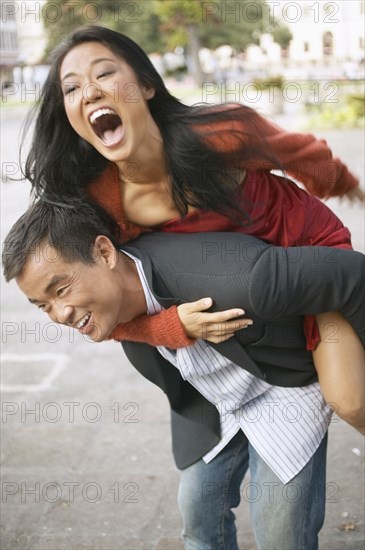 Woman riding piggyback on a young man