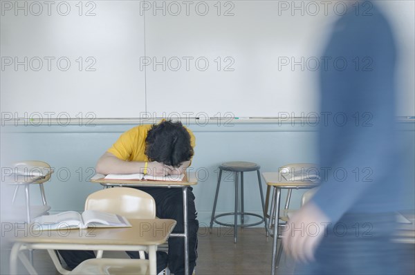 Teenage boy resting at desk