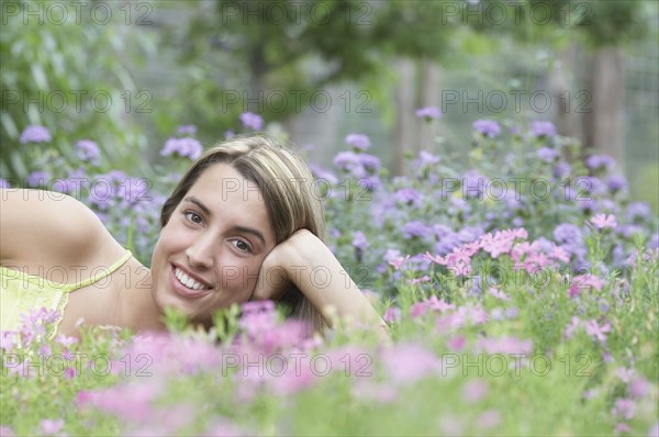 Portrait of young woman lying on grass