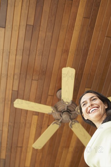 Woman standing under ceiling fan