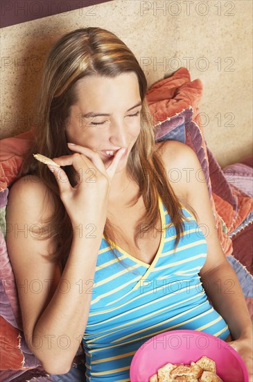 Young woman eating crackers