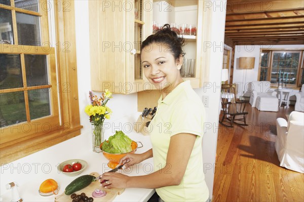 Young woman chopping vegetables in the kitchen
