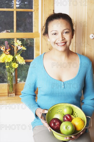 Young woman holding a bowl of fruit