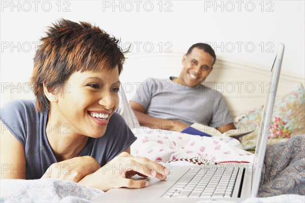 Young woman using a laptop in bed