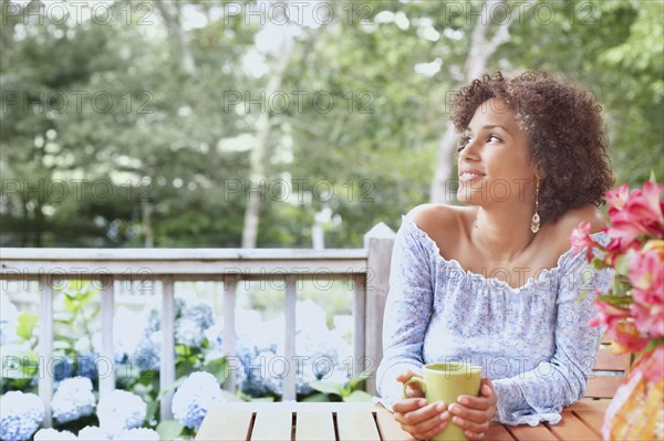 Young woman drinking a cup of coffee outdoors