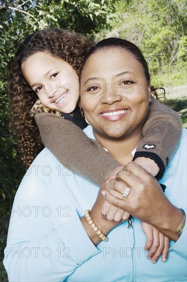 African mother and daughter hugging outdoors