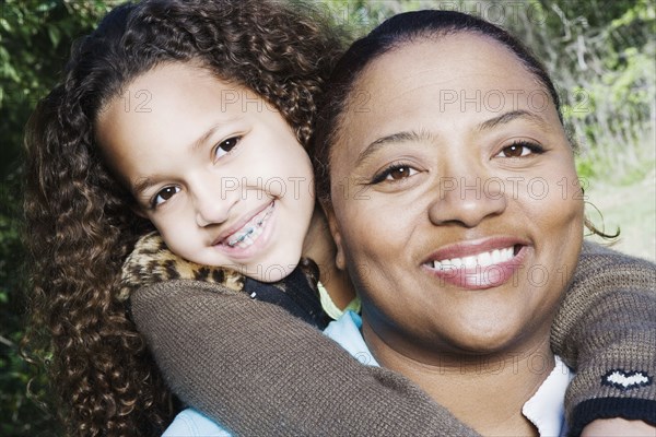 African mother and daughter hugging outdoors