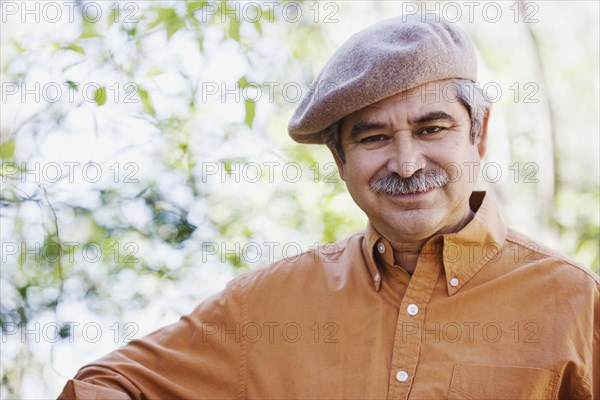 Middle-aged man wearing cap outdoors
