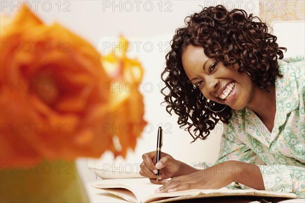 African woman writing in book
