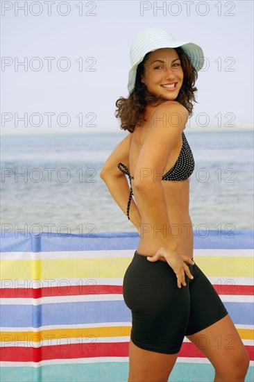 Young woman with hands on hips at beach