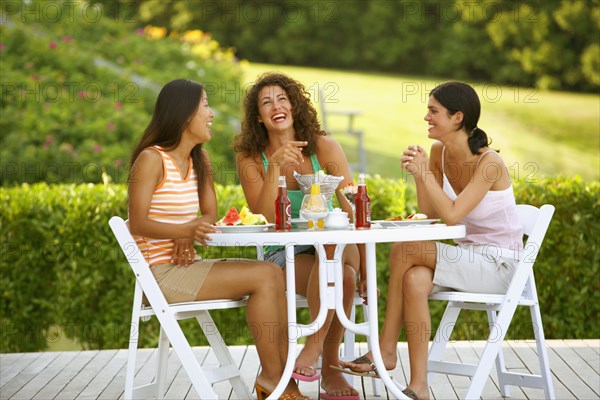 Three women eating on patio