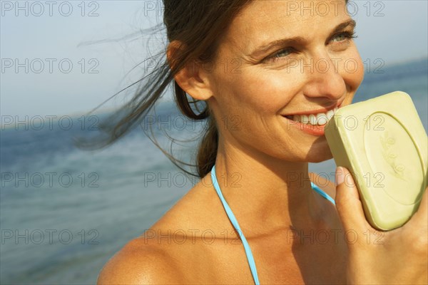 Young woman smelling soap