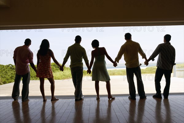 Silhouette of friends holding hands at beach resort