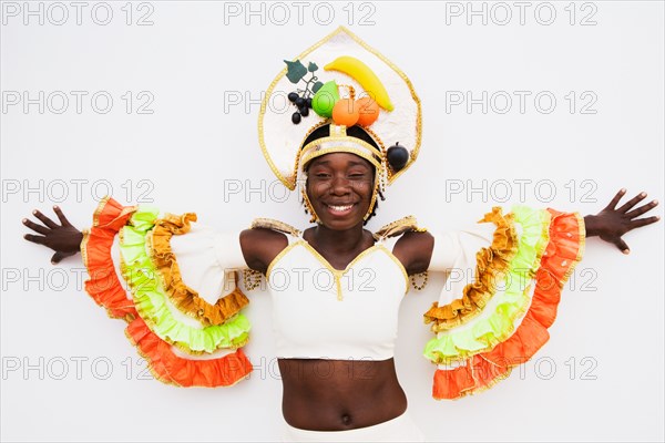 African woman wearing traditional clothing and standing with arms outstretched