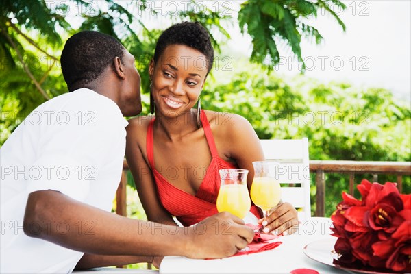 African couple drinking orange juice on patio