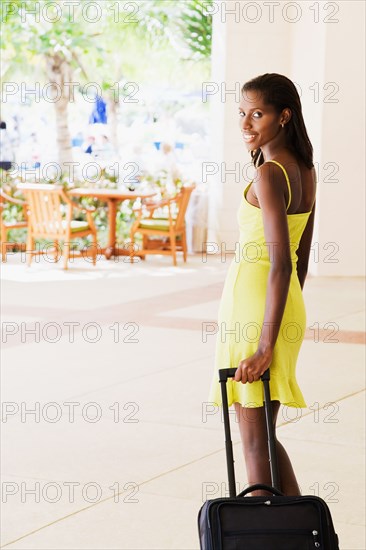 African woman pulling suitcase