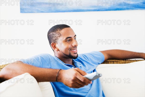 African man watching television