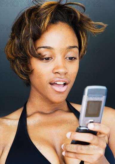 African woman looking down at cell phone