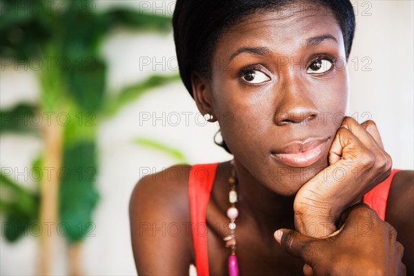 African woman looking up with head in hands