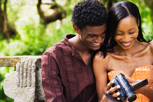 African couple looking down at video camera