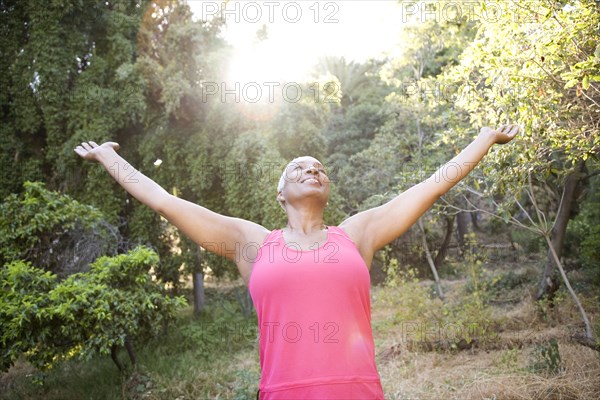 Mixed race woman outdoors with arms raised