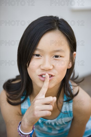 Chinese girl making shhh gesture