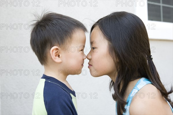 Chinese brother and sister staring at one another