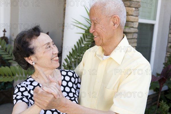 Senior Chinese couple dancing outdoors