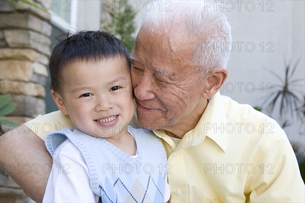 Chinese grandfather hugging grandson
