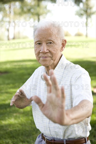 Senior Chinese man doing tai chi outdoors