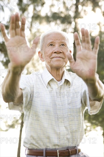 Senior Chinese man doing tai chi outdoors