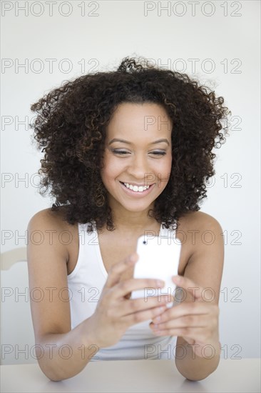 Hispanic woman text messaging on cell phone