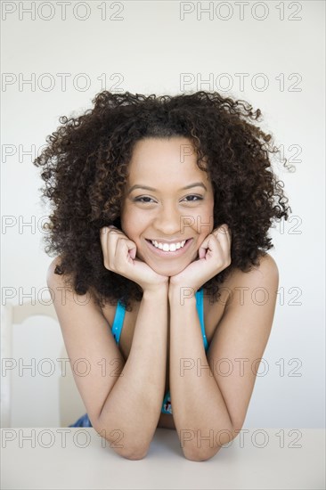 Smiling Hispanic woman with head in hands