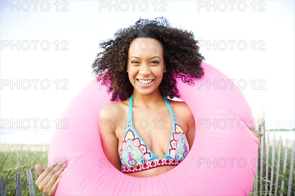 Smiling Hispanic woman holding inflatable ring