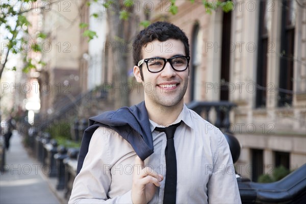 Hispanic businessman walking on city sidewalk