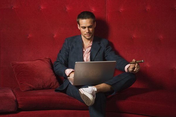 Man with cigar typing on laptop