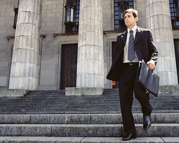 Businessman walking down stone stairs